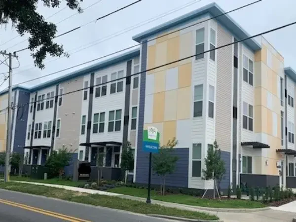 The colorful facade of The Gardens, a modern apartment building located in Lakeland, FL.
